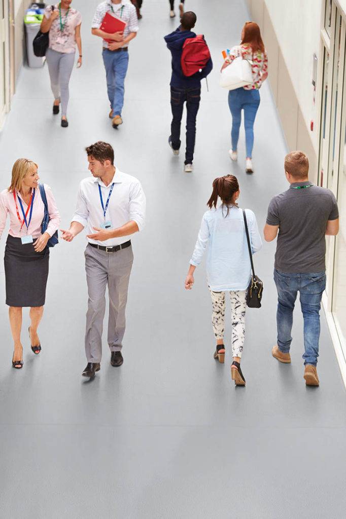 Busy Hallway In College With Students